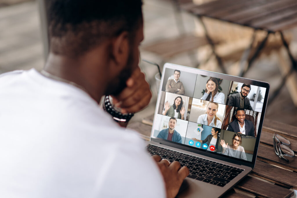 An employee attending an online meeting with his co-workers.