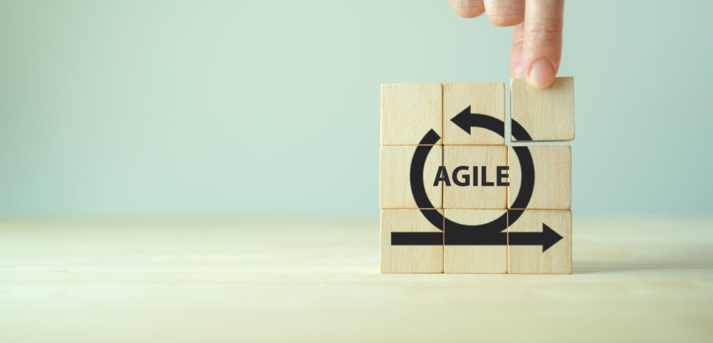 Blocks over neutral background that say Agile with the workflow arrow around it to signify agile sales.