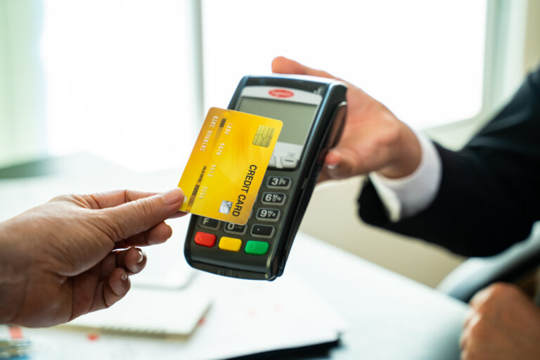 Business man holding credit card reader machine and customer paying money with contactless credit card with NFC technology to pay.