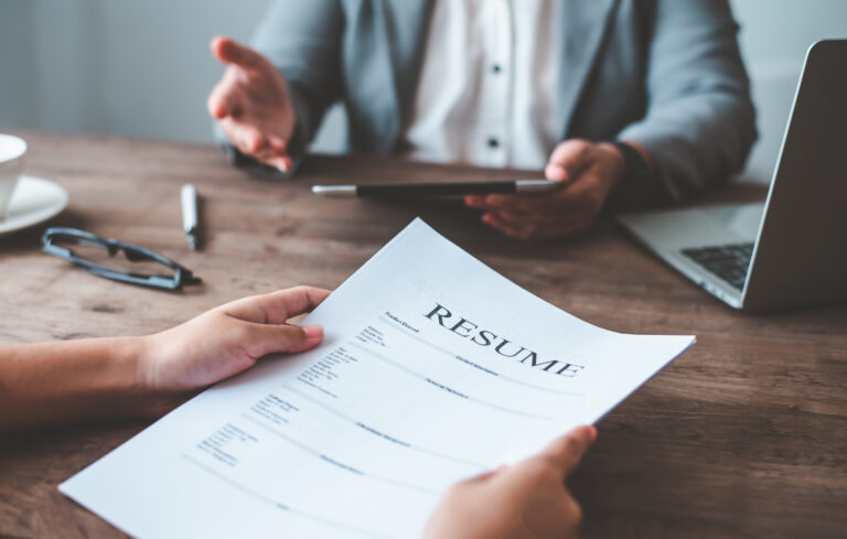 A manager checking the resume of an applicant during a job interview.