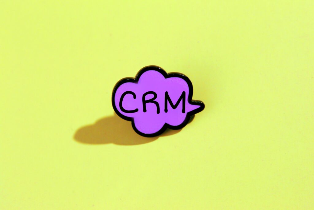 How to use crm illustrated with a pink speech cloud containing CRM on a yellow-green background.